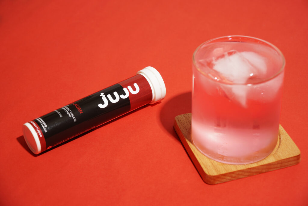 Glass and a tube container of Juju collagen that provides hydrolyzed collagen benefits.