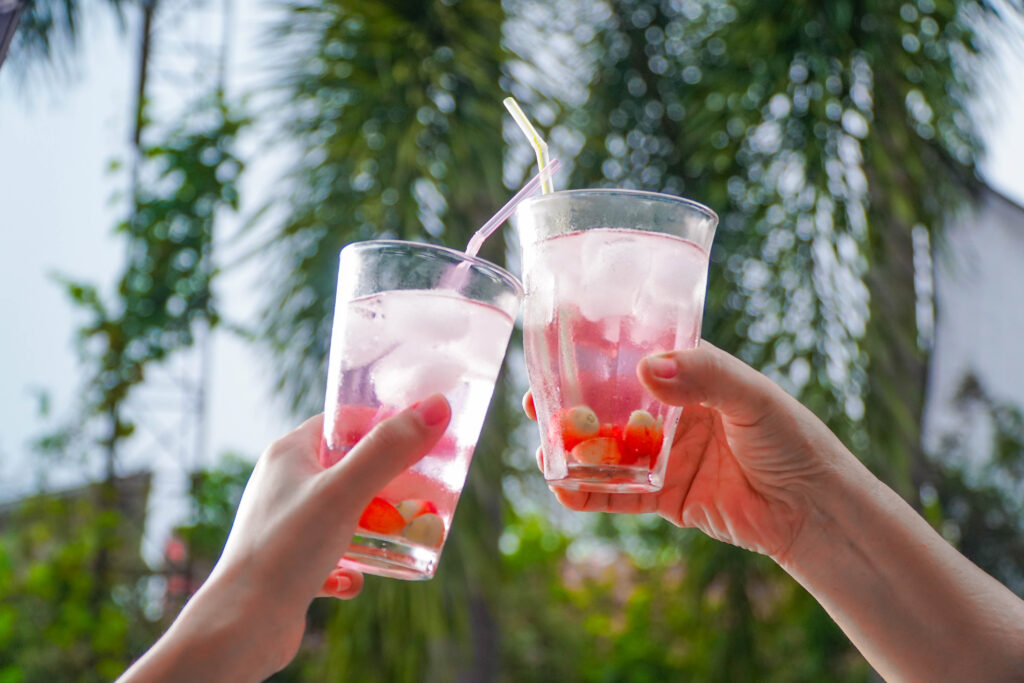 Two glasses of Juju Collagen with Vitamin C Held in the air.