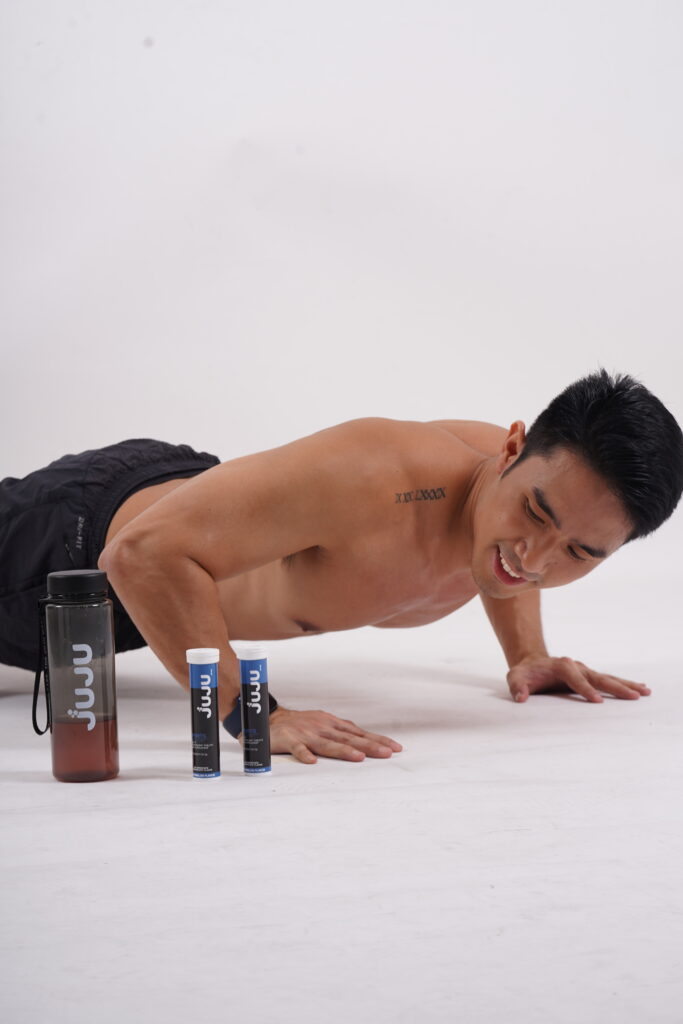 Man doing push ups with tumbler and Juju effervescent tablets on his side.