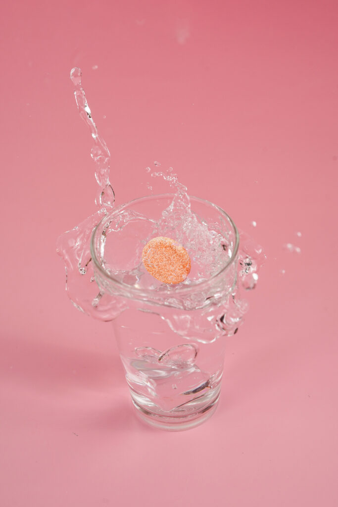 Glutathione fizz tablet dropped in a glass of water.