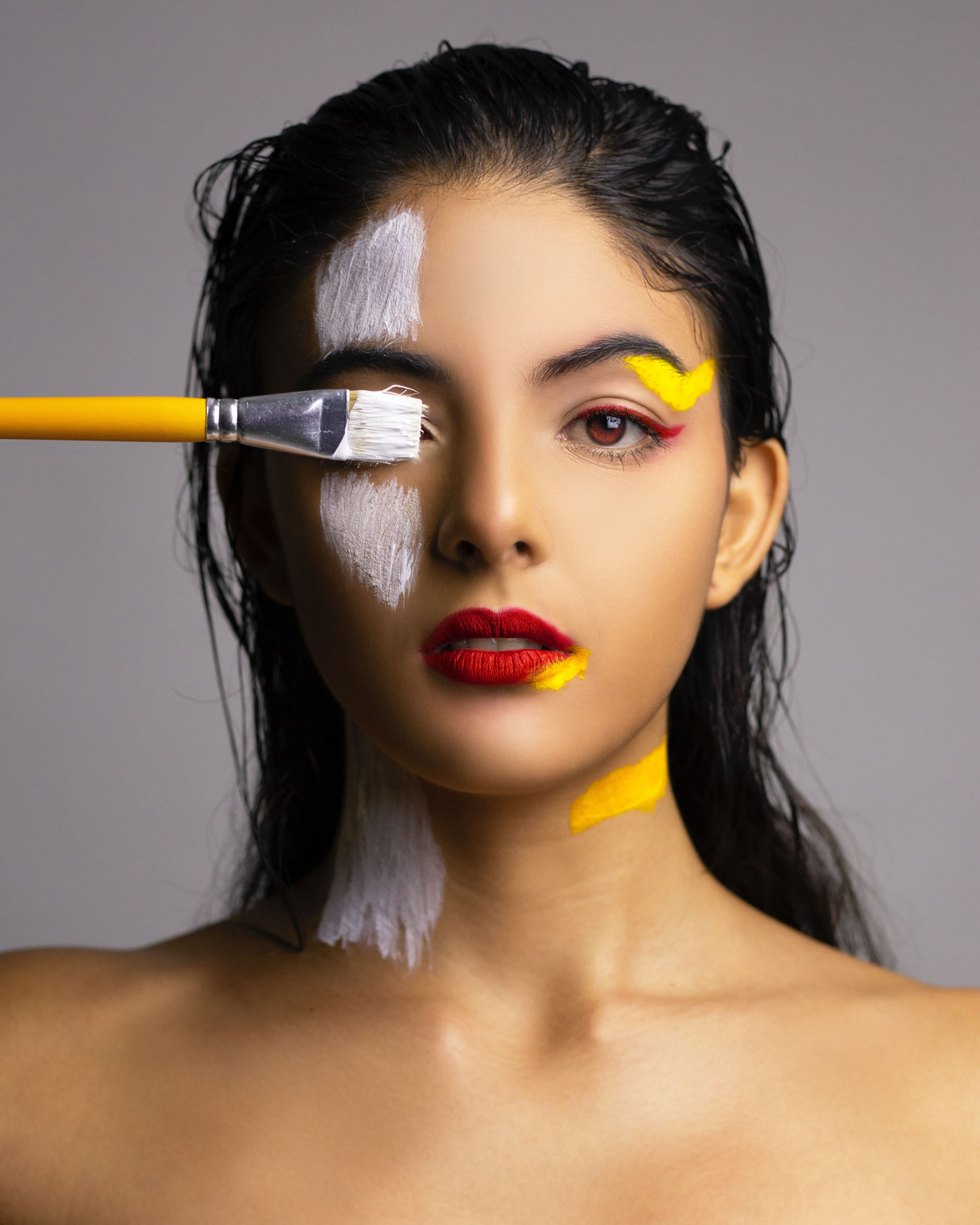 Woman with a paint brush blocking her one eye and this is for our glow up tips post.