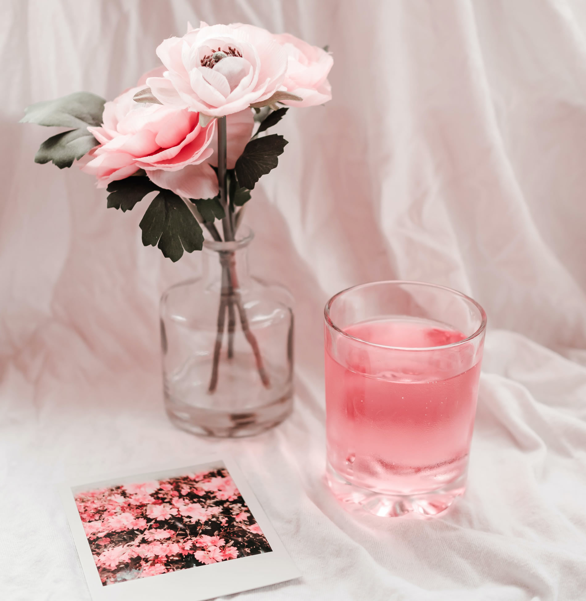 Cup of collagen juice drink on the table with roses beside it